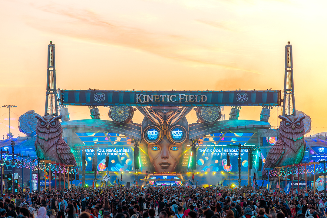 Palco kineticFIELD do EDC Las Vegas ao amanhecer, com as corujas gigantes e o céu alaranjado