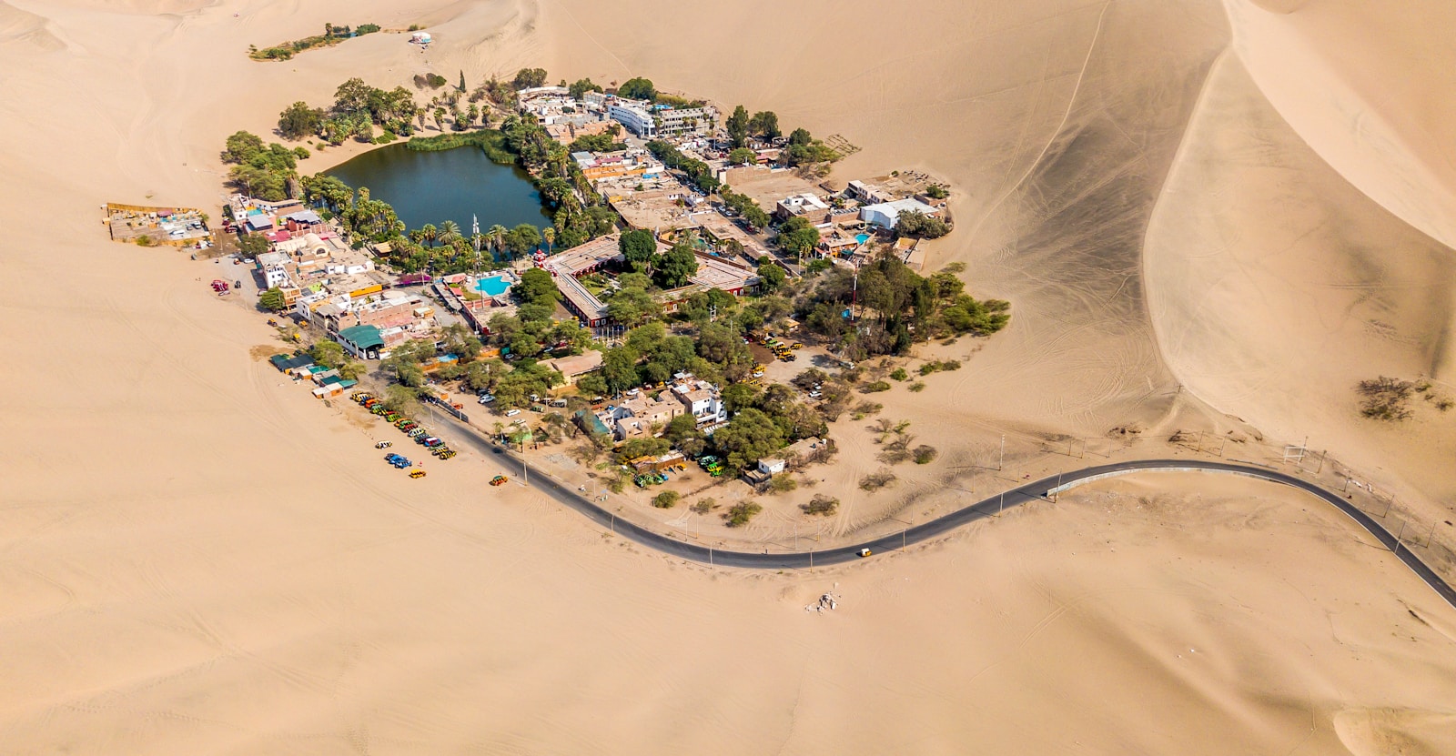 Huacachina vista do alto: a lagoa cercada de palmeiras no meio das dunas do deserto de Ica, no Peru