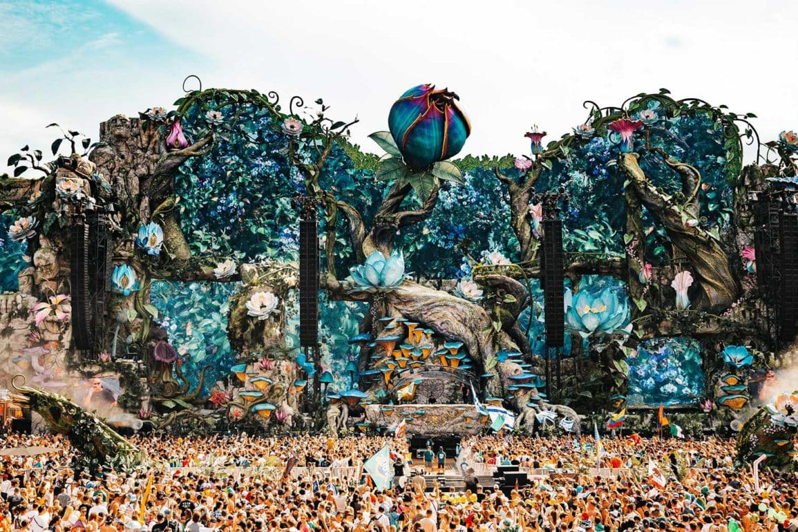 O Mainstage LIFE do Tomorrowland Brasil 2025, coberto de flores e cogumelos gigantes, com o público lotando o Parque Maeda de dia.