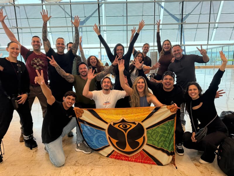 O grupo Never Ends com a bandeira do Tomorrowland no aeroporto, a caminho do festival