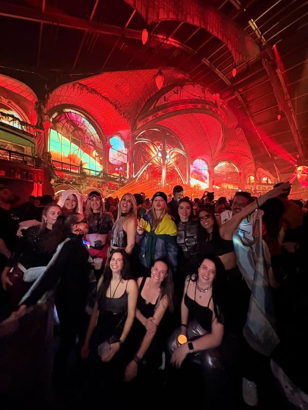 Grupo Never Ends no salão principal do Tomorrowland Winter, com os vitrais coloridos ao fundo