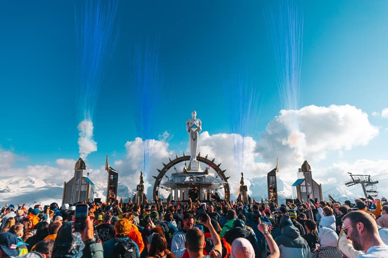 Palco no alto da montanha com fumaça azul e o teleférico ao fundo, no Tomorrowland Winter
